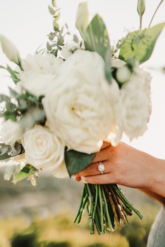 Bride holding bouquet up with ring in picture
