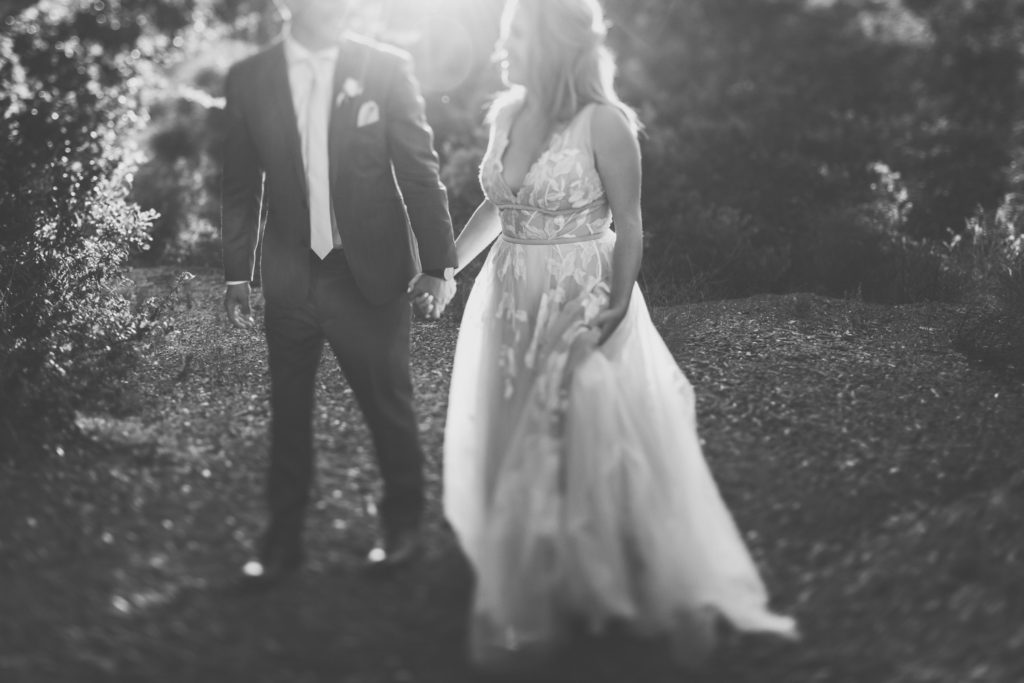 Black and white of bride and groom walking