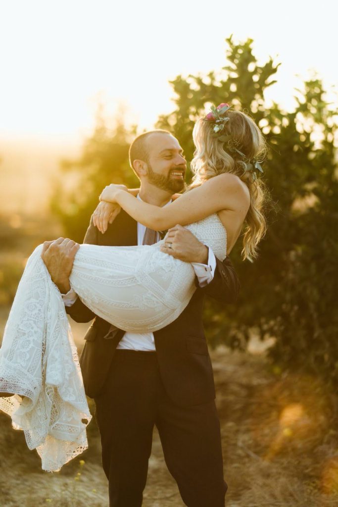 Boho wedding of bride and groom at sunset in the orange grove