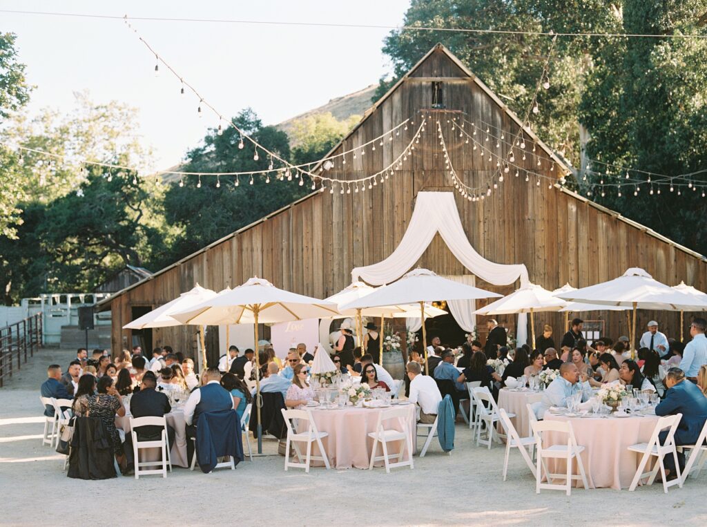 Guests eating at romantic barn wedding at La Cuesta Ranch Wedding Designed by Janet Tacy of San Luis Obispo Wedding Planner Sandcastle Celebrations captured by Jen Rodriguez Photography