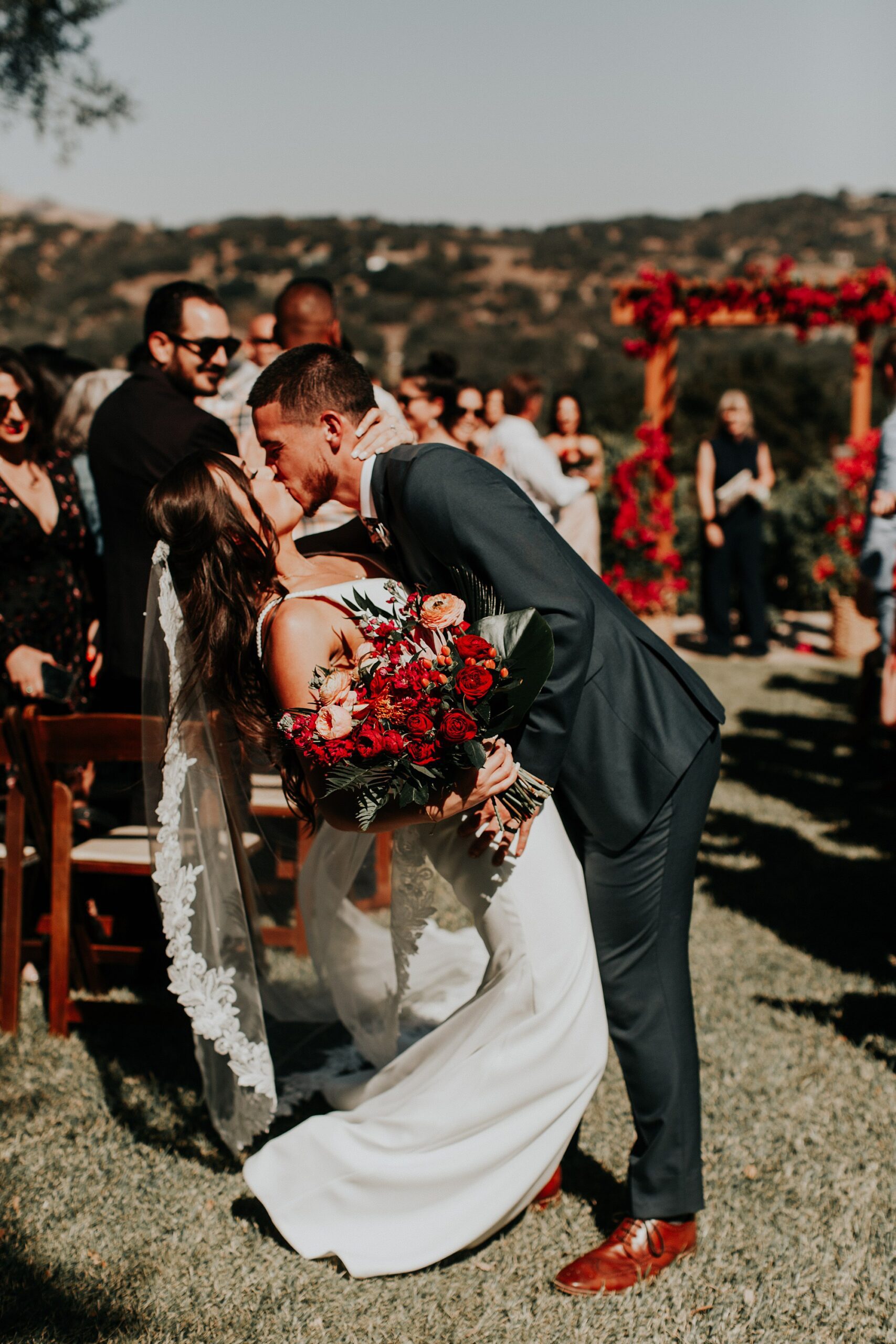 Groom kisses bride in middle of aisle at Japanese infused wedding at the Arroyo Grande Casitas Estate Wedding by SLO Wedding Planner Sandcastle Celebrations