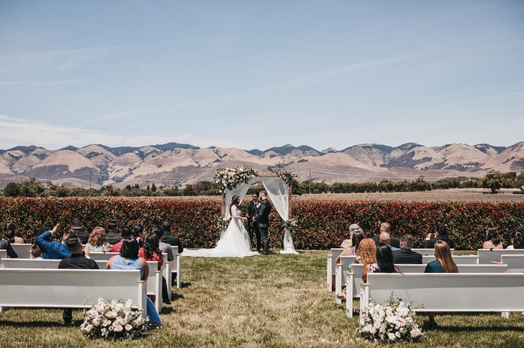 White pews in San Luis Obispo wine country at White Barn Wedding coordinated by Janet Tacy of Edna Valley Wedding Planner Sandcastle Celebrations