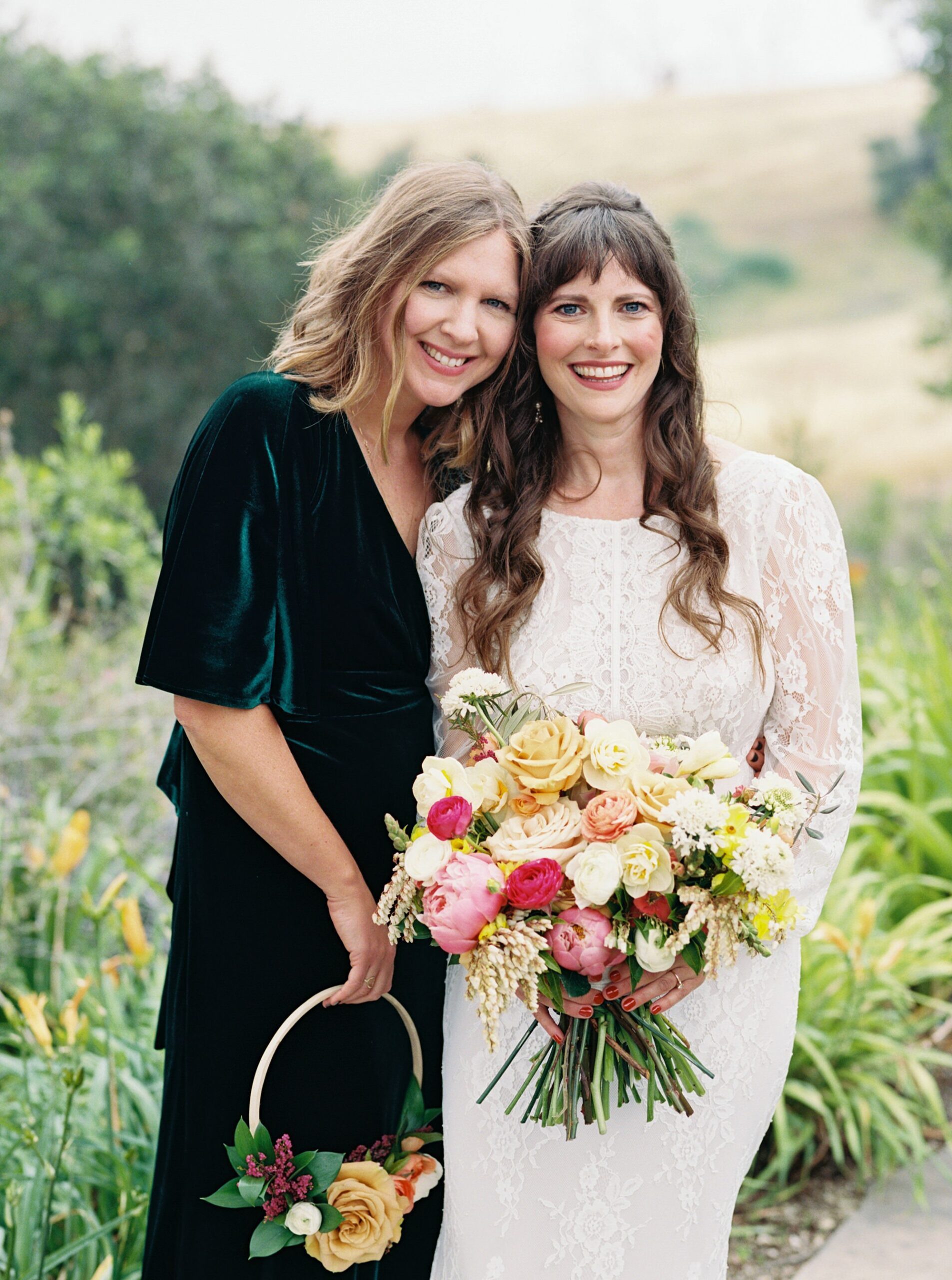 Bride and sister at unique 70s vibe colorful tangerine wedding at Casitas Estate by the best san luis obispo wedding planner Janet Tacy of Tacy and co.