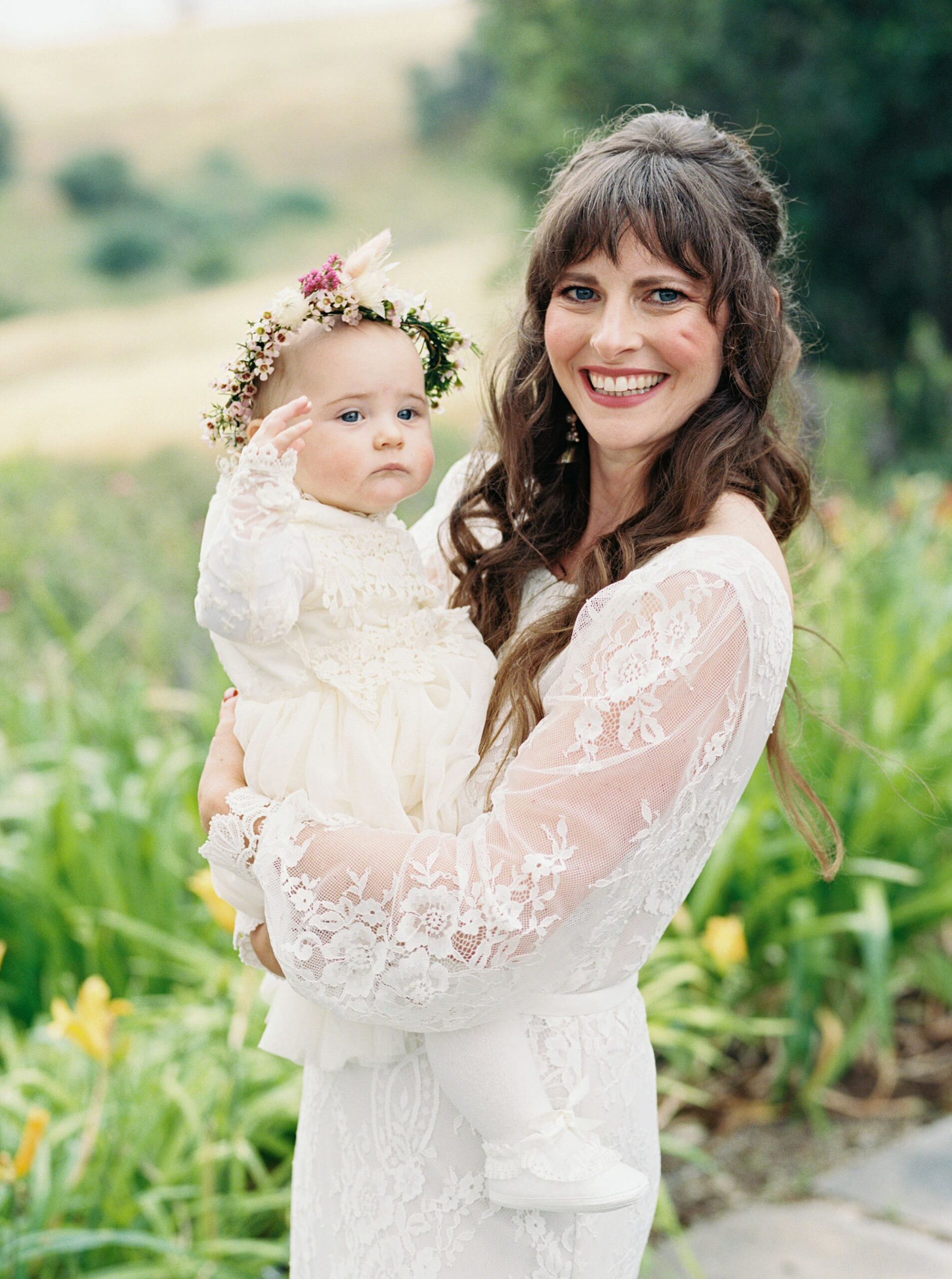 Bride with baby at unique 70s vibe colorful tangerine wedding at Casitas Estate by the best san luis obispo wedding planner Janet Tacy of Tacy and co.