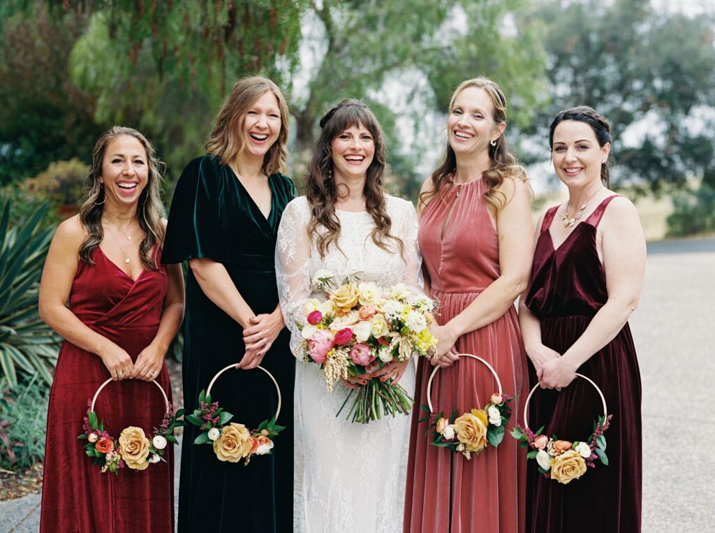 Jewel toned bridal dresses with hoop bouquets at unique 70s vibe colorful tangerine wedding at Casitas Estate by the best san luis obispo wedding planner Janet Tacy of Tacy and co.