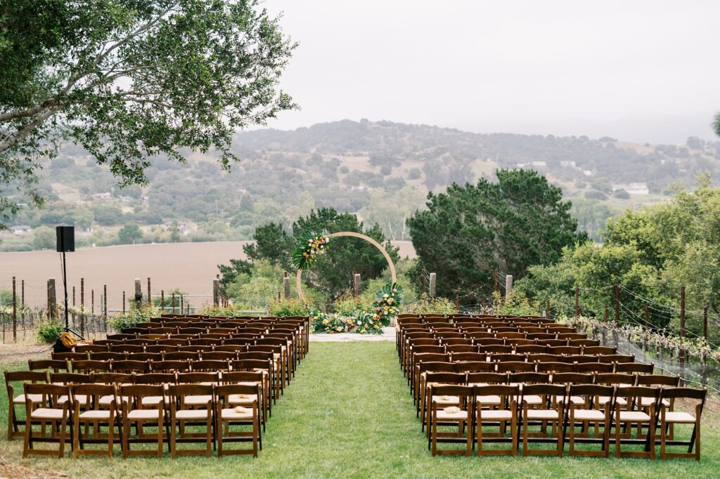 Colorful wedding ceremony at unique 70s vibe colorful tangerine wedding at Casitas Estate by the best san luis obispo wedding planner Janet Tacy of Tacy and co.