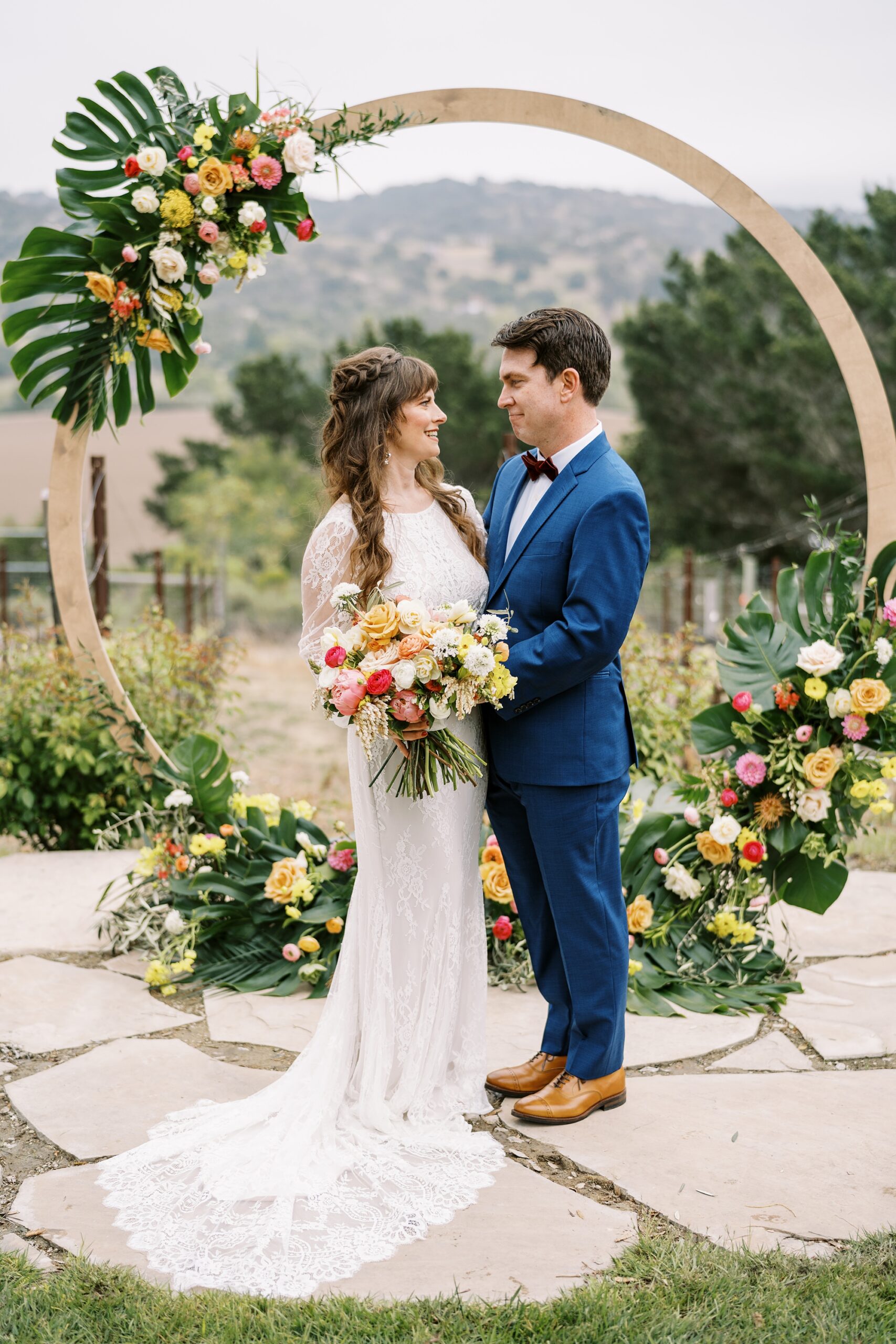 Tropical leaves and circle ceremony arbor at unique 70s vibe colorful tangerine wedding at Casitas Estate by the best san luis obispo wedding planner Janet Tacy of Tacy and co.