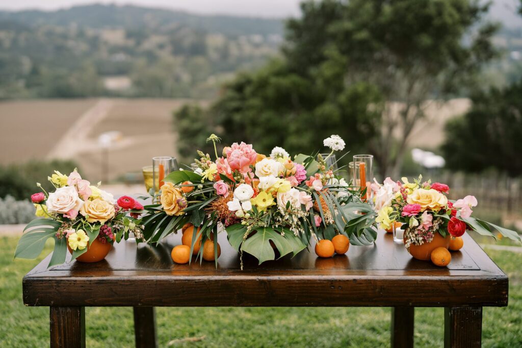 Sweetheart table with oranges at unique 70s vibe colorful tangerine wedding at Casitas Estate by the best san luis obispo wedding planner Janet Tacy of Tacy and co.