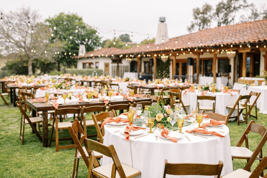 Reception tables with orange at unique 70s vibe colorful tangerine wedding at Casitas Estate by the best san luis obispo wedding planner Janet Tacy of Tacy and co.